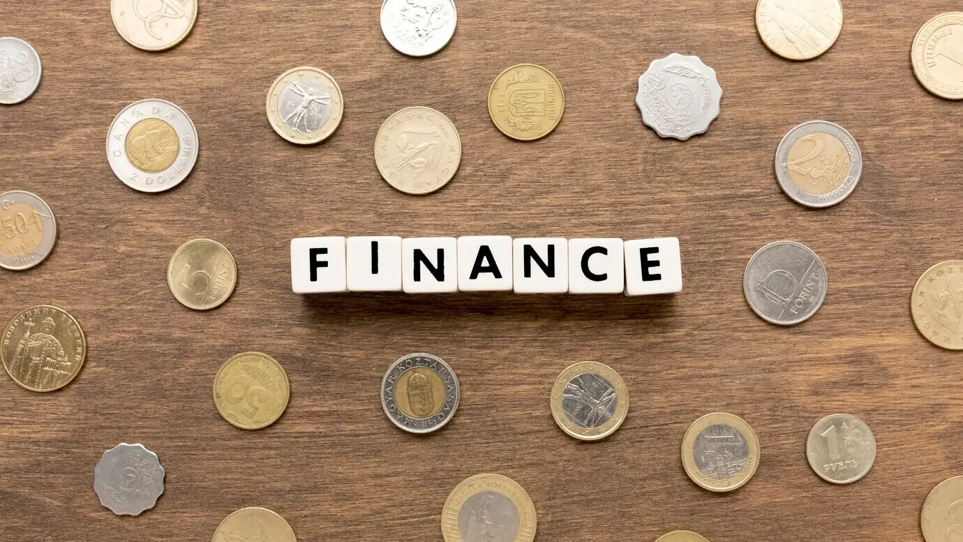 The word “Finance” written in Scrabble tiles with coins.